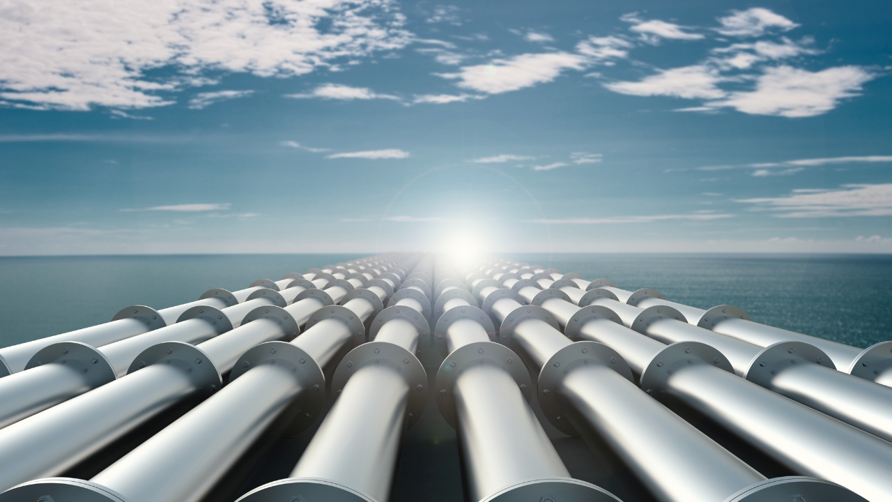 This image metaphorically depicts a network of cybersecurity pipelines, symbolizing robust data management systems crucial for digital transformation in data-driven organizations. The gleaming metallic pipelines, running along a coastal landscape under a clear sky, represent secure, integrated data channels ensuring data quality and reliability through stringent data governance. These pipelines converge towards a bright horizon, illustrating the critical role of data in business decisions and decision-making processes. The infrastructure emphasizes the importance of data accuracy, relevance, and security, highlighting the ongoing efforts in data cleansing, data validation, and adherence to data standards to mitigate data entry errors and bad data. This visual underscores the ETL (Extract, Transform, Load) process and the significance of digital security in supporting accurate and reliable business analytics and decision-making.